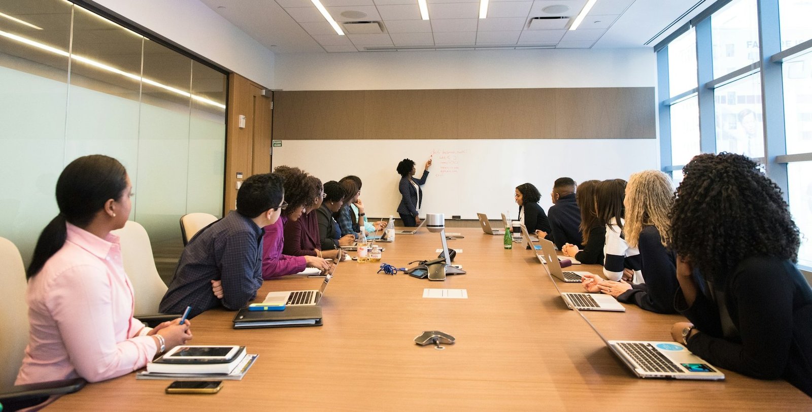 A Bridgeforce working session in a boardroom, presenter at the whiteboard