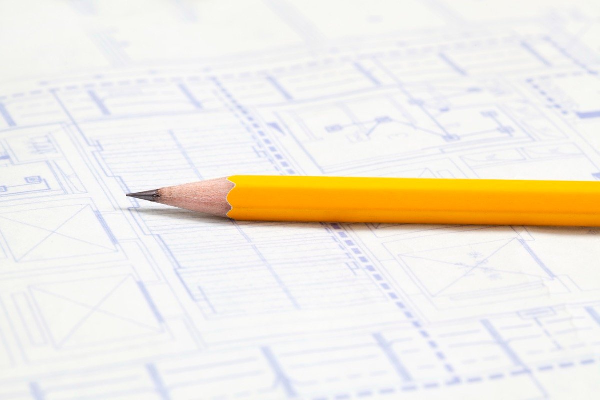 A pencil resting on blueprint drawings