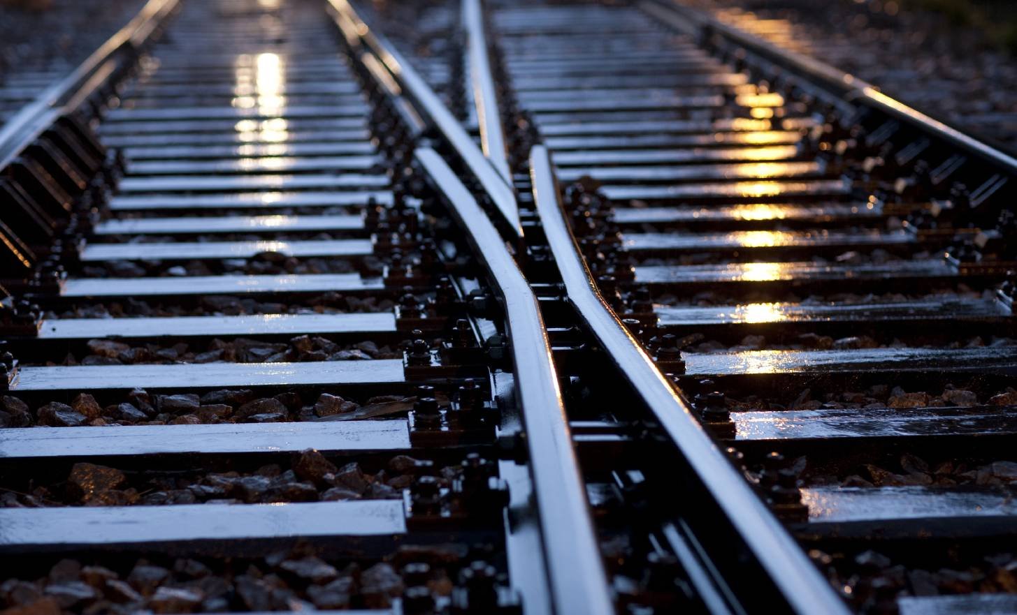 Railway switch tracks converging at dusk